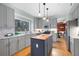 Bright kitchen with gray cabinets, stainless appliances, island, and a large window overlooking a treed backyard at 4057 Watkins Glen Dr, Woodstock, GA 30189