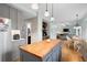 Open kitchen featuring gray cabinets, butcher block island, stainless appliances, and views to the living room at 4057 Watkins Glen Dr, Woodstock, GA 30189