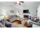 Comfortable living room with a fireplace, neutral-toned sofas, a ceiling fan, and views of the backyard at 4057 Watkins Glen Dr, Woodstock, GA 30189