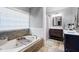 Bathroom featuring a tub with stone surround, and double vanity at 4057 Watkins Glen Dr, Woodstock, GA 30189