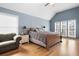 Bright main bedroom with light blue walls, multiple windows, and hardwood floors at 4057 Watkins Glen Dr, Woodstock, GA 30189