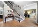 Elegant staircase with dark wood railing and patterned wallpaper, flowing into adjacent living spaces at 4057 Watkins Glen Dr, Woodstock, GA 30189