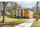 Eye-catching two-story residence with a modern orange and white facade, set on a verdant lawn with mature trees at 576 Quillian Ave, Decatur, GA 30032