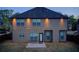 View of the home's backyard, featuring a well-maintained lawn and illuminated exterior at 2580 Brittany Park Cv, Ellenwood, GA 30294