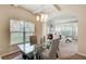 Charming dining area with modern chandelier, glass table, and adjacent living room at 2580 Brittany Park Cv, Ellenwood, GA 30294