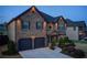 Exterior view of a two-story home with stone accents, landscape lighting and two-car garage at 2580 Brittany Park Cv, Ellenwood, GA 30294