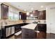 Well-lit kitchen with stainless steel appliances, granite countertops, wooden cabinets, and a kitchen island at 2580 Brittany Park Cv, Ellenwood, GA 30294