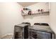 Modern laundry room with new washer and dryer and storage shelf at 2580 Brittany Park Cv, Ellenwood, GA 30294