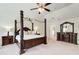 Comfortable bedroom with a dark wooden four-poster bed, matching nightstands, dressers, and a ceiling fan at 2580 Brittany Park Cv, Ellenwood, GA 30294