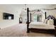 Large main bedroom featuring vaulted ceilings, dark wood four-poster bed, ceiling fan, and cozy sitting area at 2580 Brittany Park Cv, Ellenwood, GA 30294