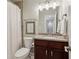 Cozy bathroom featuring a dark vanity, granite countertop, toilet and tiled shower/tub at 4988 Meadow Ln, Marietta, GA 30068