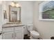 Bathroom features white vanity with granite countertop, large mirror and toilet near a window at 4988 Meadow Ln, Marietta, GA 30068