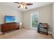 Bedroom with window, dresser with TV, carpeted floor and ceiling fan at 4988 Meadow Ln, Marietta, GA 30068