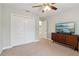 Bedroom with closet, dresser with television, carpeted floor and ceiling fan at 4988 Meadow Ln, Marietta, GA 30068
