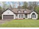 Charming white brick home featuring a well-manicured lawn, dormers, and a two-car garage at 5233 Hayden Farms Dr, Powder Springs, GA 30127