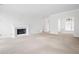 Bright living room features a white fireplace, neutral carpet, and view into another room at 5233 Hayden Farms Dr, Powder Springs, GA 30127