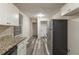 Galley kitchen featuring stainless steel appliances, granite countertops and adjacent laundry area at 388 Belgarde Se Pl, Atlanta, GA 30354