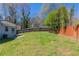 Picture of a large backyard with a partial wooden fence and mature trees, perfect for outdoor activities at 5224 Sweet Air Ln, Stone Mountain, GA 30088