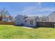 View of the spacious backyard with a partial fence, lush green grass, and mature trees at 5224 Sweet Air Ln, Stone Mountain, GA 30088