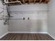 Unfinished basement area featuring wood-look flooring and exposed ceiling with a wire shelf for storage at 5224 Sweet Air Ln, Stone Mountain, GA 30088