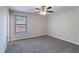 Carpeted bedroom with a ceiling fan, neutral walls, and a window offering natural light at 5224 Sweet Air Ln, Stone Mountain, GA 30088