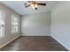 Spacious living room featuring dark laminate flooring, neutral walls, and plenty of natural light from the windows at 5224 Sweet Air Ln, Stone Mountain, GA 30088