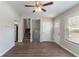 Inviting living room featuring dark laminate flooring, ceiling fan, staircase, and easy access to the front door at 5224 Sweet Air Ln, Stone Mountain, GA 30088