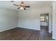 Bright living room featuring sleek, dark laminate flooring and a modern ceiling fan with an open view to the kitchen at 5224 Sweet Air Ln, Stone Mountain, GA 30088