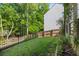 Backyard features a grassy lawn area with mature trees and an iron fence at 557 Winder Trl, Canton, GA 30114