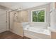 Bright bathroom features a large soaking tub, glass shower, and wood-look flooring at 557 Winder Trl, Canton, GA 30114