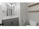 Stylish half bathroom featuring a gray vanity with a white countertop, floating shelves, and modern fixtures at 557 Winder Trl, Canton, GA 30114