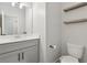 Modern bathroom with gray vanity, quartz countertop, dual sinks, and floating wooden shelves at 557 Winder Trl, Canton, GA 30114
