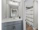 Modern bathroom with gray cabinets, quartz countertop, and decorative framed mirror at 557 Winder Trl, Canton, GA 30114