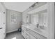Bright bathroom with double sinks, gray cabinets, modern lighting, and a large mirror at 557 Winder Trl, Canton, GA 30114