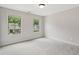 Bright bedroom features two windows and neutral walls, highlighting the plush carpet at 557 Winder Trl, Canton, GA 30114