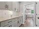 Hallway view of a gray butler's pantry with white subway tile backsplash at 557 Winder Trl, Canton, GA 30114