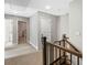 Upstairs hallway featuring carpet, wood railing, and a view into an adjacent room with a crib at 557 Winder Trl, Canton, GA 30114