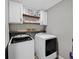 Modern laundry room with cabinetry, shelving and a side-by-side washer and dryer at 557 Winder Trl, Canton, GA 30114