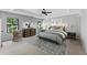 Staged main bedroom featuring a tray ceiling, large windows, stylish furniture, and a patterned area rug at 557 Winder Trl, Canton, GA 30114