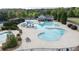Aerial view of a community pool with a slide, seating, and mature landscaping at 557 Winder Trl, Canton, GA 30114