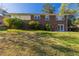 Well-maintained backyard showcasing a spacious grassy area and the rear facade of a brick home with a walkout basement at 761 Caron Nw Cir, Atlanta, GA 30318