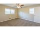 A bright, carpeted bedroom with a ceiling fan and two windows providing natural light at 761 Caron Nw Cir, Atlanta, GA 30318