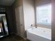 Bathroom featuring a tub, window with blinds, and wall decor at 1980 Beyers Landing Dr, Buford, GA 30519