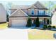 Charming two-story home featuring stone accents, well-manicured lawn, and a two-car garage at 1980 Beyers Landing Dr, Buford, GA 30519