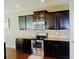 A kitchen featuring dark cabinetry, stainless steel appliances, and granite countertops at 1980 Beyers Landing Dr, Buford, GA 30519