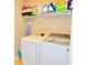 Functional laundry area with front-load washer, dryer, and shelving for storage at 1980 Beyers Landing Dr, Buford, GA 30519