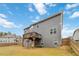 Rear exterior of gray home with a wooden deck overlooking a large fenced-in yard at 3478 Spring Place Ct, Loganville, GA 30052
