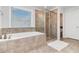 This bathroom features a soaking tub, glass-enclosed shower, and large window at 3478 Spring Place Ct, Loganville, GA 30052