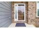 Welcoming entrance with a storm door and neutral-toned brick and siding at 3478 Spring Place Ct, Loganville, GA 30052
