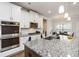 Modern kitchen with stainless steel appliances, granite countertops, and island with bar seating at 3478 Spring Place Ct, Loganville, GA 30052